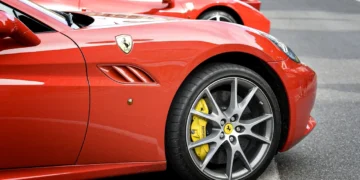 تصویر ردیفی از خودروهای قرمز Ferrari با تمرکز بر رینگ آلیاژی خاکستری و کالیپر ترمز زرد، نماد دقت مهندسی و اصالت برند فراری.