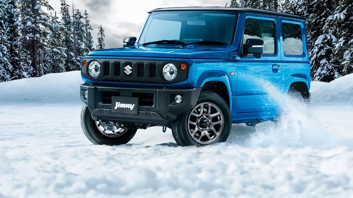 نمای جلوی Suzuki Jimny 2026 در رنگ آبی هنگام حرکت روی برف با طراحی کلاسیک و چراغهای گرد