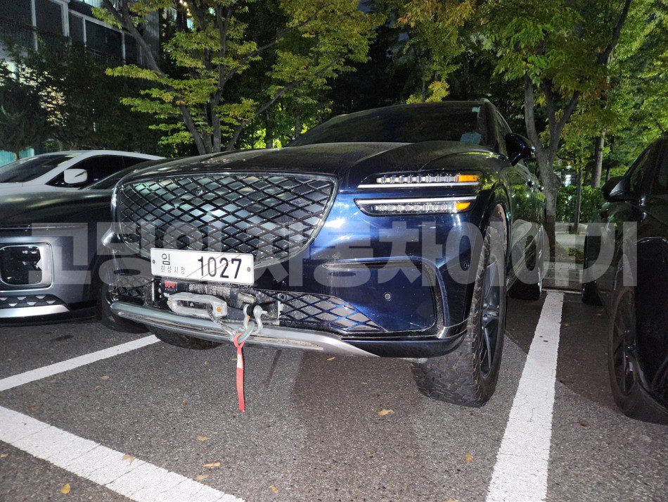 نمای جلوی کامل از شاسیبلند آزمایشی جنسیس با جلوپنجره بزرگ لوزیشکل، چراغهای LED افقی و قلاب بکسل در بخش پایینی سپر جلو