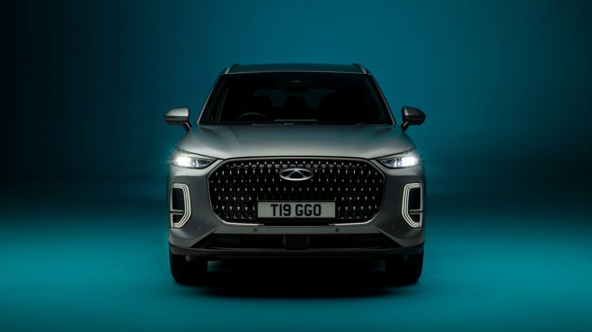 نمای جلویی شاسی‌بلند Chery Tiggo 9 Super Hybrid با چراغ‌های LED عمودی و جلوپنجره بزرگ مشکی در پس‌زمینه آبی استودیو