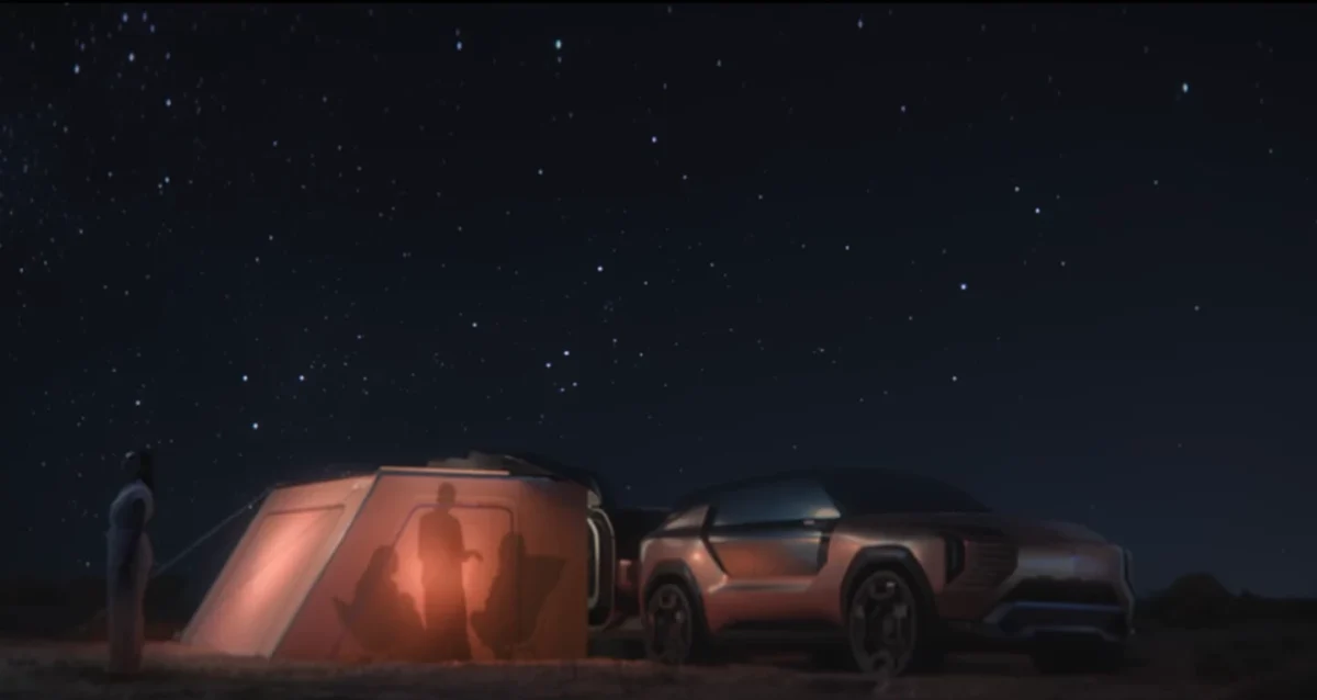 نمای شب Mitsubishi Elevance در کنار تریلر روشنشده و چادر کمپ در زیر آسمان پرستاره.