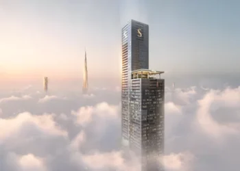 برج بلند Sobha SkyParks در میان ابرهای دوبی با منظره Burj Khalifa در پسزمینه.