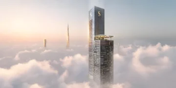برج بلند Sobha SkyParks در میان ابرهای دوبی با منظره Burj Khalifa در پس‌زمینه.