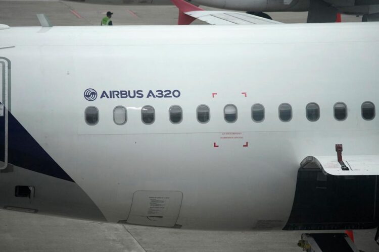 نمای نزدیک از بدنه یک هواپیمای ایرباس A320، نشان دادن نام "AIRBUS A320" و ردیفی از پنجره&zwnj;ها.
