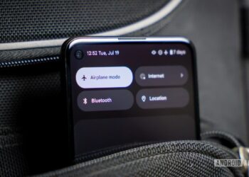 نمای نزدیک از یک گوشی اندروید که دکمه "Airplane mode" در منوی تنظیمات سریع آن فعال است و گوشی در یک جیب یا کیف مشکی قرار دارد.
