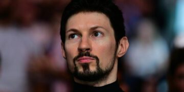 پاول دوروف، بنیانگذار تلگرام، با یقه اسکی مشکی و ریش بزی در حال نگاه کردن به سمت راست با پس‌زمینه‌ای محو.