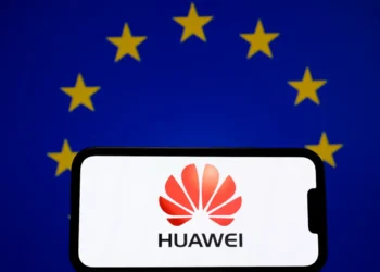 نمایشگر یک گوشی که لوگوی هواوی را روی پسزمینه اتحادیه اروپا نشان میدهد