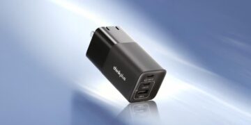 شارژر Lenovo ThinkPlus 100W GaN مشکی رنگ با سه پورت (USB-C1، USB-C2 و USB-A) که از نمای مورب بر روی یک پسزمینه آبی ملایم دیده میشود.
