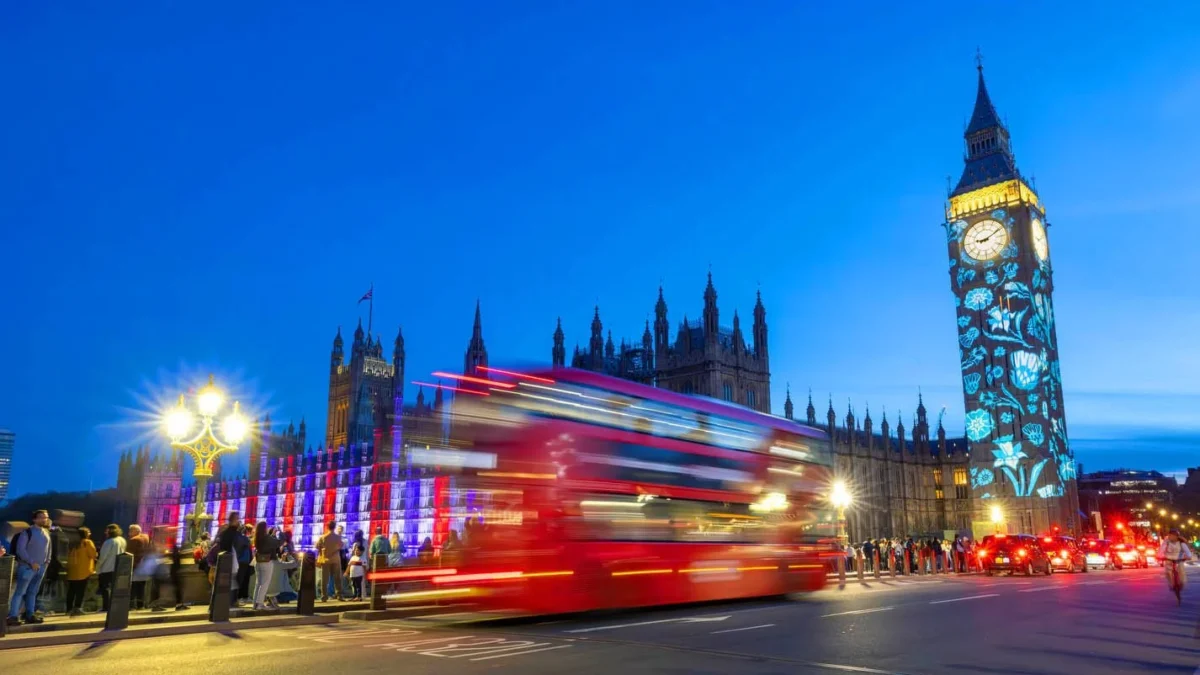 منظره شب لندن با برج بیگ بن، اتوبوس قرمز و نورپردازی خیابان