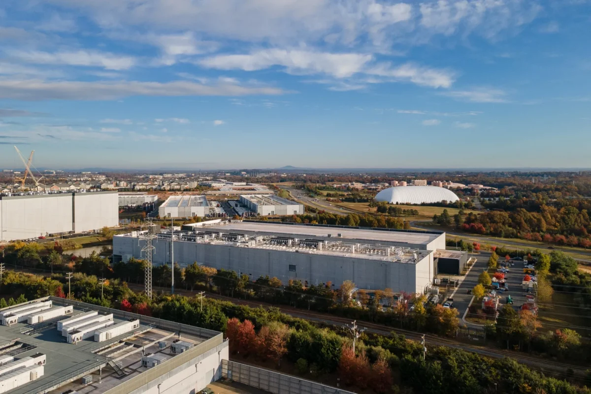 نمای هوایی از یک مجموعه بزرگ مرکز داده متا در یک محیط حومه شهر در زیر آسمان آبی.