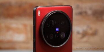 نمای نزدیک از ماژول دوربین پشتی یک گوشی هوشمند قرمز رنگ (احتمالاً Vivo X100 Pro) با چهار لنز و برند ZEISS در یک ماژول دایرهای بزرگ.