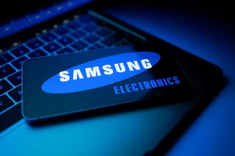 یک کارت که لوگوی "SAMSUNG ELECTRONICS" بر روی صفحه آن دیده می‌شود و روی یک صفحه کلید لپ‌تاپ در محیطی با نورپردازی آبی تاریک قرار دارد.