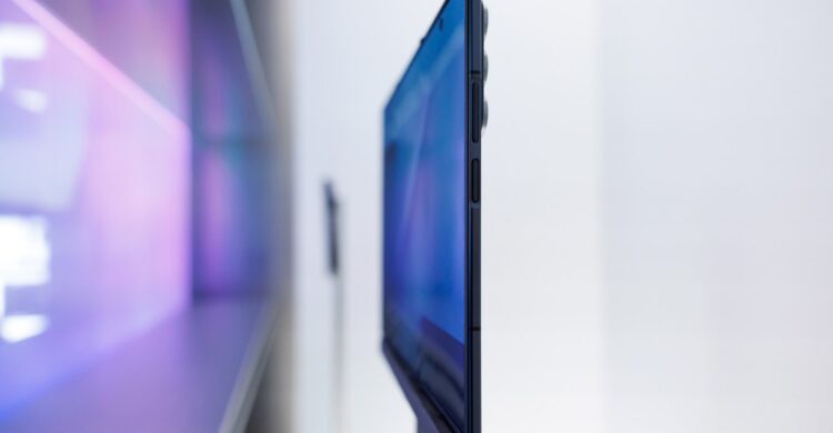 نمای نزدیک از لبه یک گوشی تاشو سه‌لته‌ای (Tri-Fold) که دکمه‌های کناری و ضخامت آن را نشان می‌دهد.