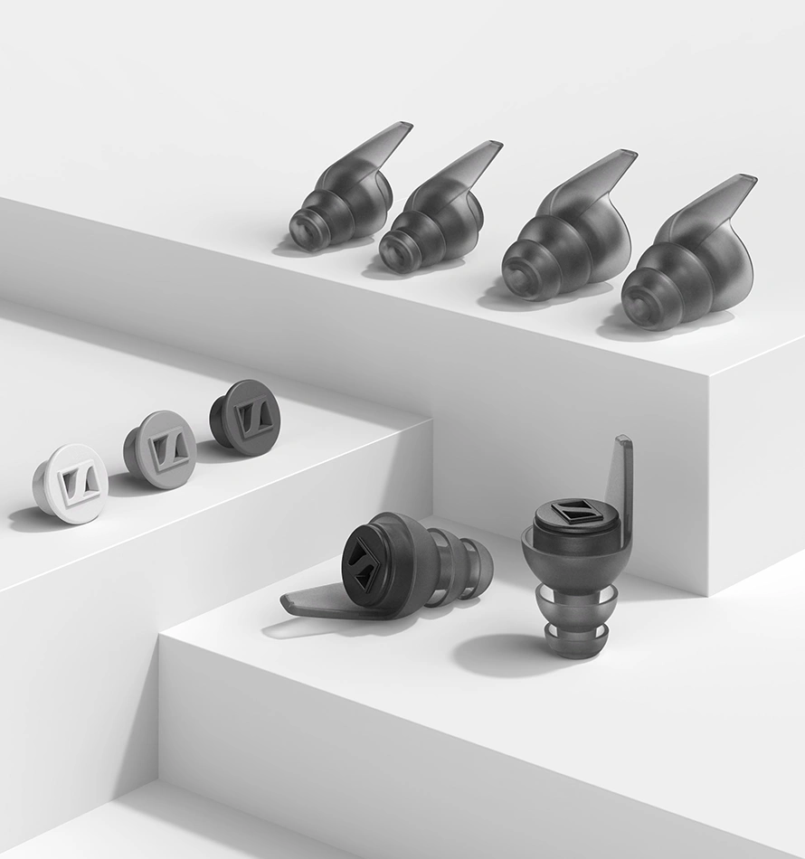 ایرپلاگهای Sennheiser SoundProtex Plus در رنگها و اندازههای مختلف که بر روی یک سطح سفید و پلهای به صورت مرتب چیده شدهاند.