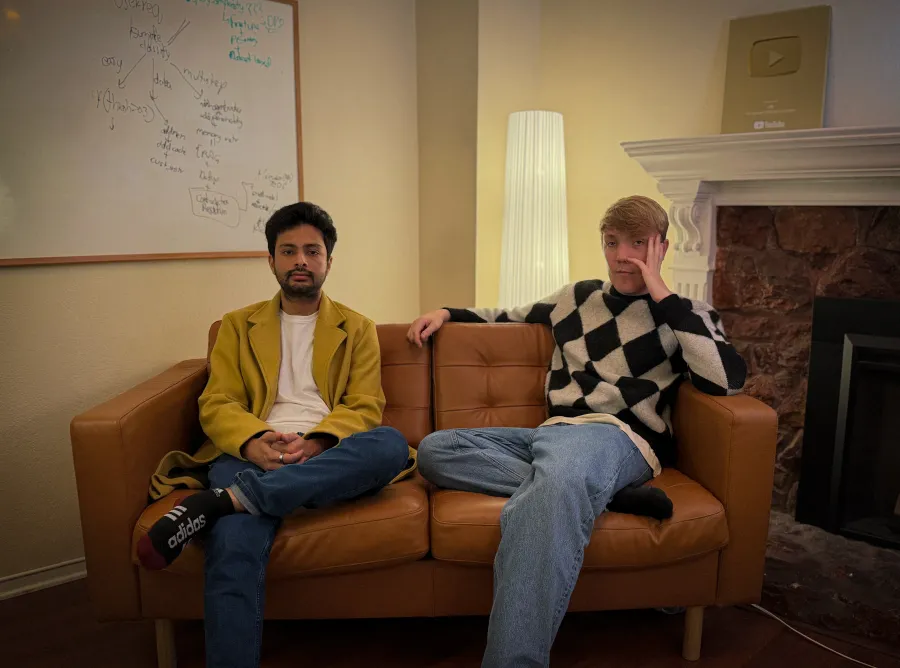 پرتره دو بنیانگذار، شیوام کومار (Shivam Kumar) و جک ویلینگام (Jack Willingham)، که روی یک کاناپه چرمی نشسته‌اند و یک تخته سفید با نوشته‌های کد در پشت آن‌ها دیده می‌شود.