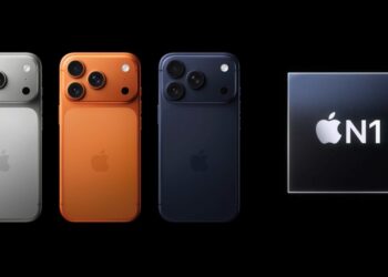 سه گوشی iPhone 17 از نمای پشت در رنگ‌های نقره‌ای، نارنجی و آبی تیره با ماژول‌های دوربین سه‌گانه، که در سمت راست آن‌ها یک تراشه سیاه با لوگوی سفید "Apple N1" قرار دارد.