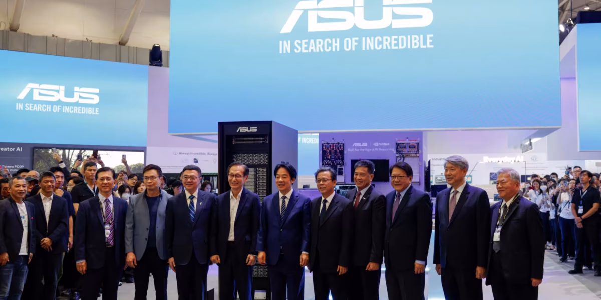 گروهی از سیاستمداران و مقامات تایوانی، از جمله رئیس‌جمهور، در حال ایستادن در مقابل یک غرفه نمایشگاهی بزرگ با لوگوی ASUS و شعار "IN SEARCH OF INCREDIBLE".