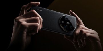 نمای پشت گوشی Xiaomi با بافت چرمی سیاه و ماژول دوربین بزرگ دایره‌ای Leica، که توسط دو دست در حالت افقی نگه داشته شده است.