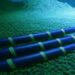 کابل‌های ارتباطی زیردریایی آبی تیره با نوارهای سبز روشن که روی کف دریا با پوشش گیاهی یا جلبک‌های سبز و آبی قرار گرفته‌اند.