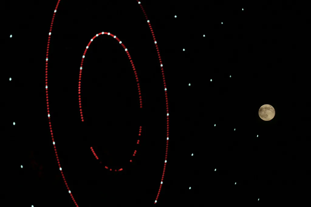 یک چرخ در حال چرخش، پیشزمینهای خیرهکننده به عکسی از ماه بر فراز شهر ادلب در شمال سوریه بخشیده است.