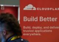 یک بنر تبلیغاتی Cloudflare با لوگوی سفید و شعار "Build Better" که در یک رویداد یا کنفرانس دیده میشود.