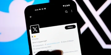 لوگوی X (توییتر سابق) روی صفحه گوشی هوشمند که پروفایل X (@X) را در حالت تاریک نشان می‌دهد.