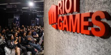 نمای داخلی رویداد League of Legends با تمرکز بر لوگوی Riot Games روی دیوار و فضای سالن، مرتبط با برگزاری ایونت رسمی، مسابقات یا برنامه‌ های رقابتی Worlds