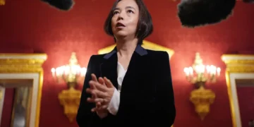 تصویری از فی فی لی با پوشش رسمی و در حال مصاحبه