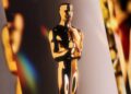 کی‌آرت رسمی نود و هفتمین دوره جوایز اسکار با نمایش مجسمه طلایی آکادمی در پس‌زمینه‌ای درخشان، مرتبط با مراسم Oscars 2025
