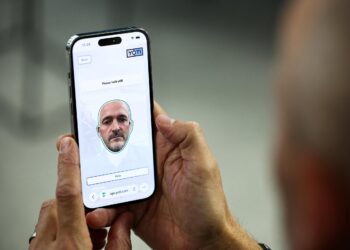 کاربر در حال استفاده از اپلیکیشن Yoti برای تأیید سن با فناوری تشخیص چهره روی گوشی هوشمند