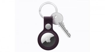 ردیاب هوشمند ایرتگ (AirTag) اپل که درون یک جاکلیدی چرمی بنفش قرار گرفته و به کلید متصل است.