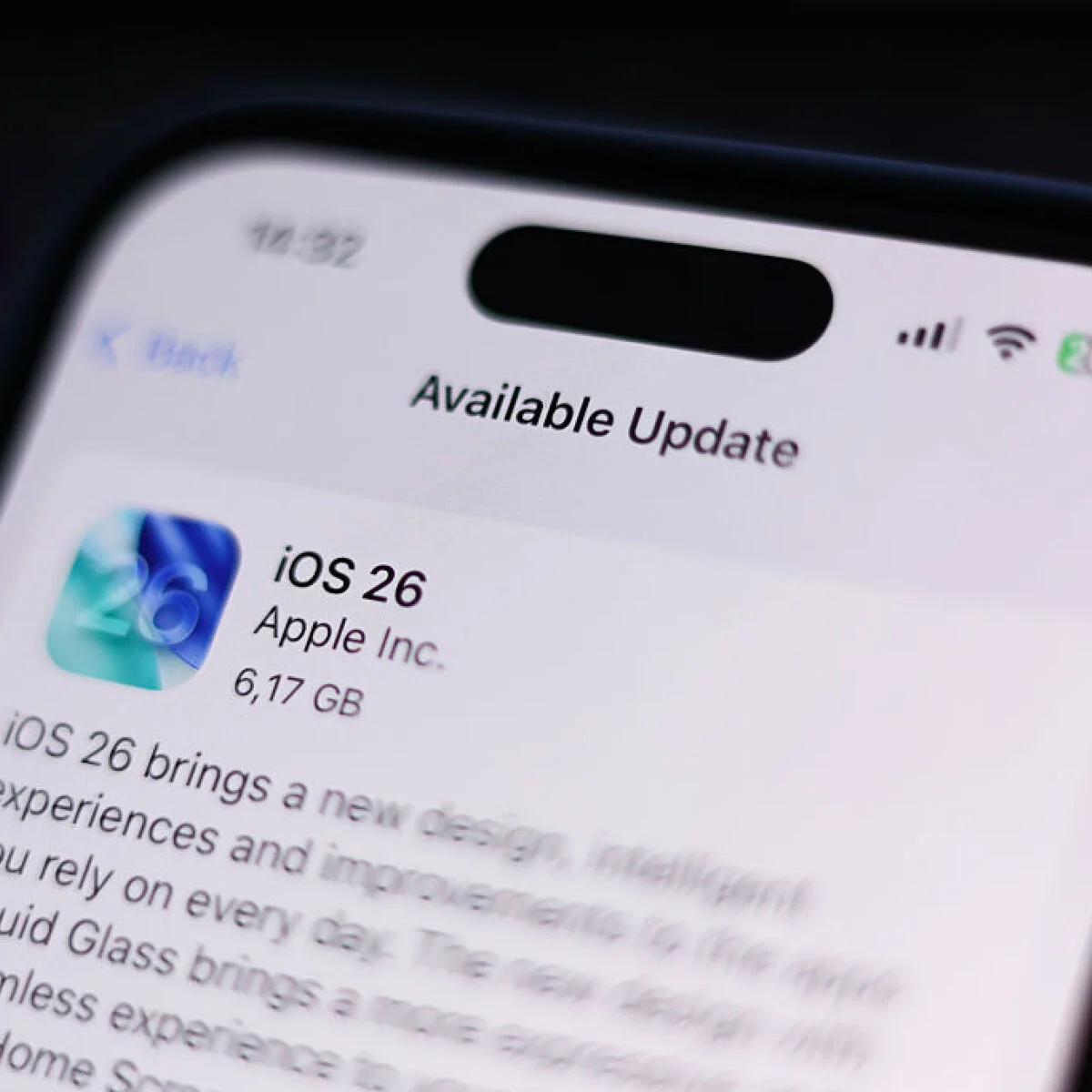 نمای نزدیک از صفحه نمایش آیفون در بخش تنظیمات، در حال نمایش اعلان آپدیت iOS 26.