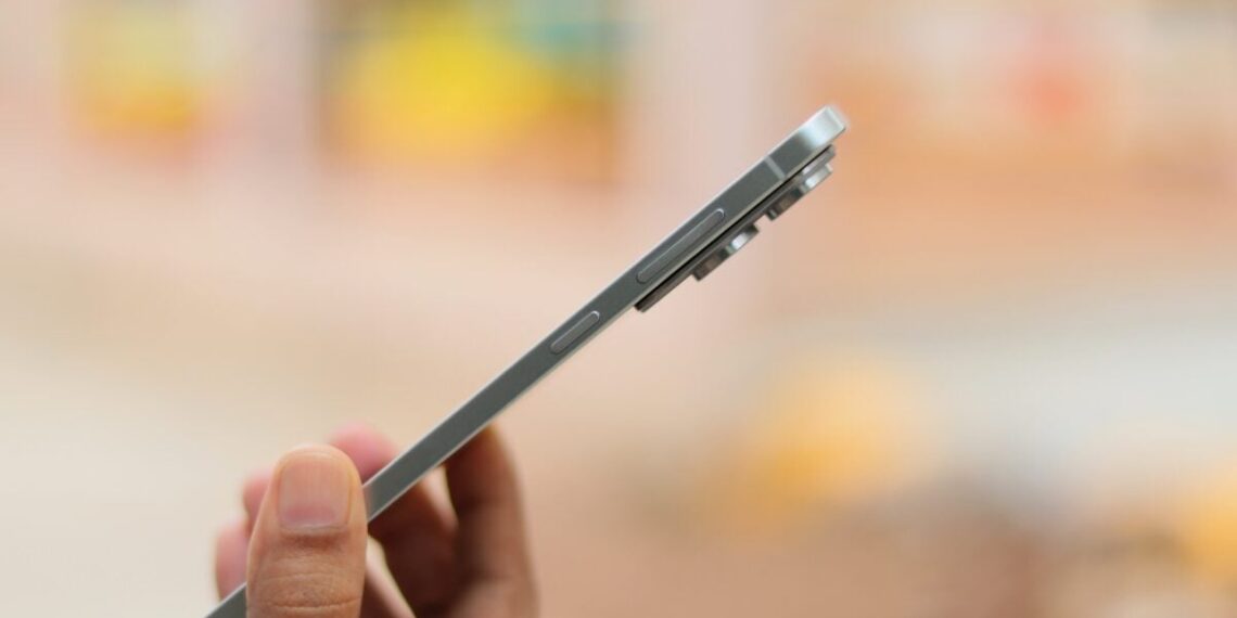 نمای نزدیک از لبه کناری و بسیار باریک یک گوشی هوشمند نقره‌ای رنگ.