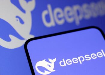 لوگوی DeepSeek (شکل نهنگ) روی صفحه نمایش تلفن هوشمند و یک مانیتور.