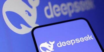 لوگوی DeepSeek (شکل نهنگ) روی صفحه نمایش تلفن هوشمند و یک مانیتور.