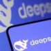 لوگوی DeepSeek (شکل نهنگ) روی صفحه نمایش تلفن هوشمند و یک مانیتور.