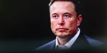 پرتره نزدیک از ایلان ماسک با چهره‌ای جدی در یک محیط رسمی یا مصاحبه.