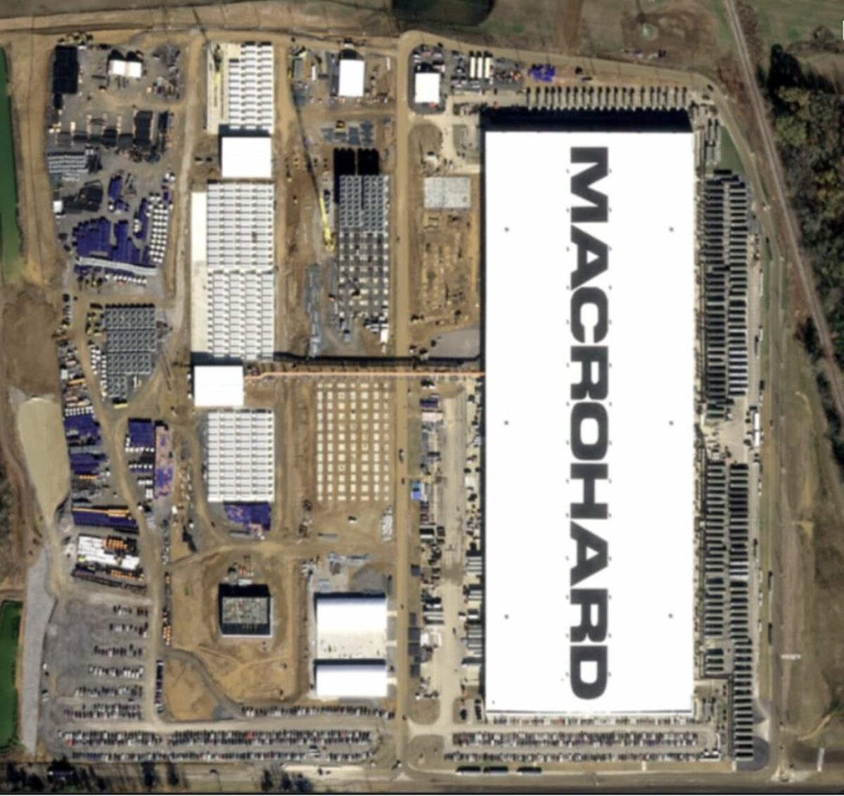 نمای هوایی از یک دیتاسنتر عظیم با کلمه "MACROHARD" که روی سقف آن نوشته شده است.