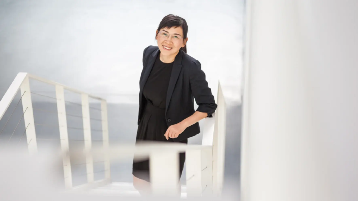 پرتره زنی با کت و دامن مشکی ایستاده روی راه‌پله سفید (مرتبط با خبر نقشه سه‌بعدی).