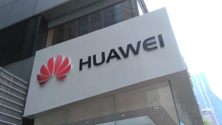 نمای بیرونی ساختمان هوآوی با لوگوی قرمز Huawei و تابلو سفیدرنگ در نمای شهری مدرن، نشان&zwnj;دهنده هویت برند و دفتر رسمی شرکت هوآوی در حوزه فناوری و ارتباطات