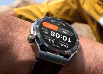 نمای نزدیک ساعت هوشمند هواوی (Huawei Watch) روی مچ دست با نمایش اطلاعات محیطی.