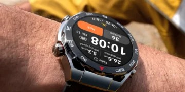 نمای نزدیک ساعت هوشمند هواوی (Huawei Watch) روی مچ دست با نمایش اطلاعات محیطی.