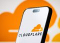 تصویر گوشی هوشمند که لوگوی Cloudflare را در پس‌زمینه‌ای نارنجی نمایش می‌دهد.