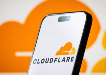تصویر گوشی هوشمند که لوگوی Cloudflare را در پس‌زمینه‌ای نارنجی نمایش می‌دهد.