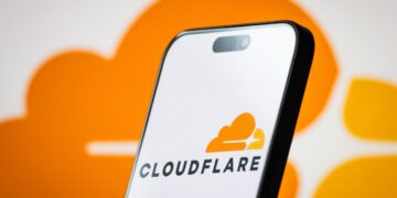 تصویر گوشی هوشمند که لوگوی Cloudflare را در پسزمینهای نارنجی نمایش میدهد.