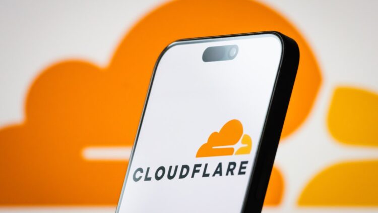 تصویر گوشی هوشمند که لوگوی Cloudflare را در پس‌زمینه‌ای نارنجی نمایش می‌دهد.
