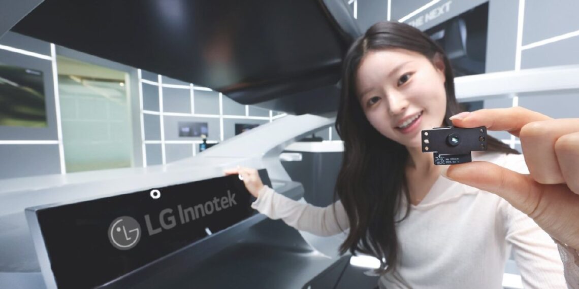 نمای دیگری از کارمند LG Innotek که ماژول حسگر دوربین را در محیط داخلی یک خودروی مدرن نشان می‌دهد.