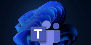 لوگوی برنامه Microsoft Teams (یک مربع بنفش با حرف T و دو شکل فرد) بر روی پس‌زمینه تیره والپیپر انتزاعی Windows 11 با رنگ آبی.