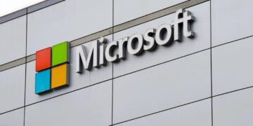 لوگوی چهاررنگ و نام شرکت مایکروسافت بر روی نمای بدنه یک ساختمان مدرن.