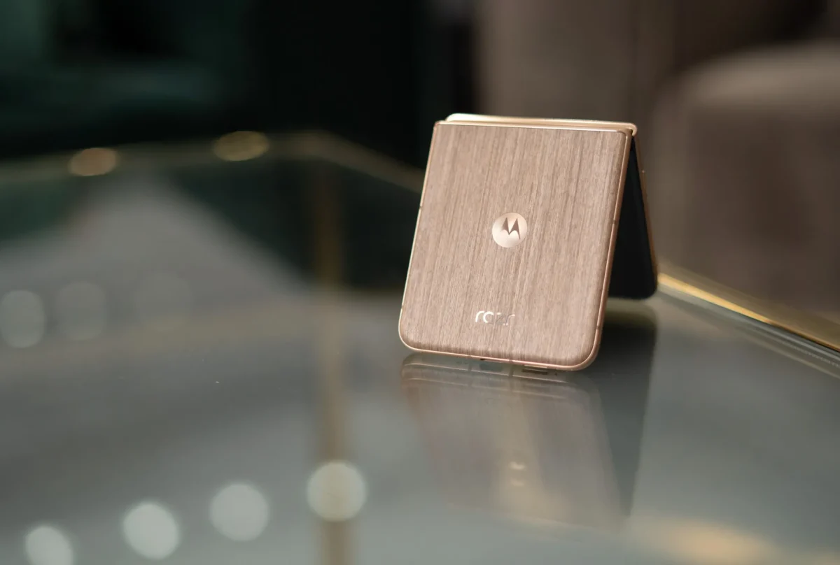 گوشی تاشوی موتورولا ریزر (Motorola Razr) با بدنه طرح چوب که به صورت نیمه‌باز روی میز شیشه‌ای قرار دارد.